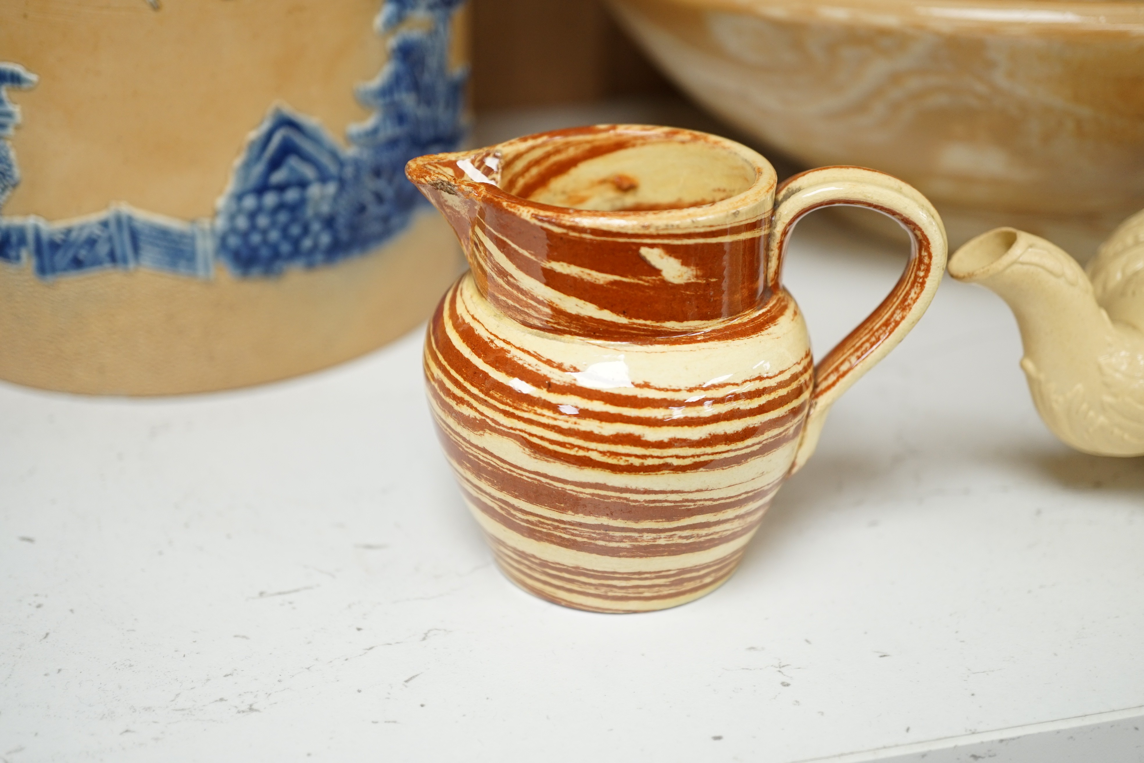 A Victorian solid agate ware pottery jug, a similar bowl and pair of miniature jugs, an unusual Doulton Lambeth stoneware jug and a small relief-moulded teapot, Doulton jug, 19cms high